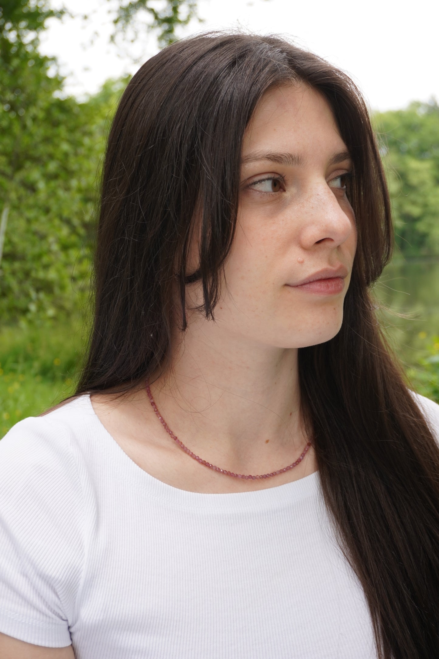 Frau trägt filigrane Edelsteinkette aus facettierten pinken Turmalin.