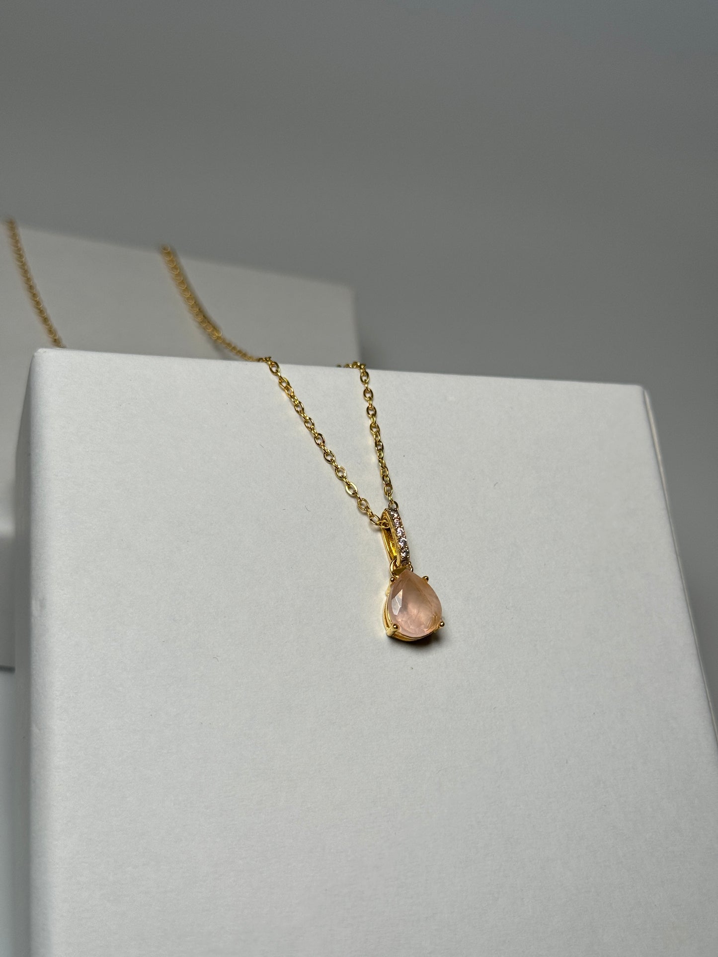 Zarte Halskette mit Rosenquarz und Zirkonia-Tropfenanhänger an goldender Kette.