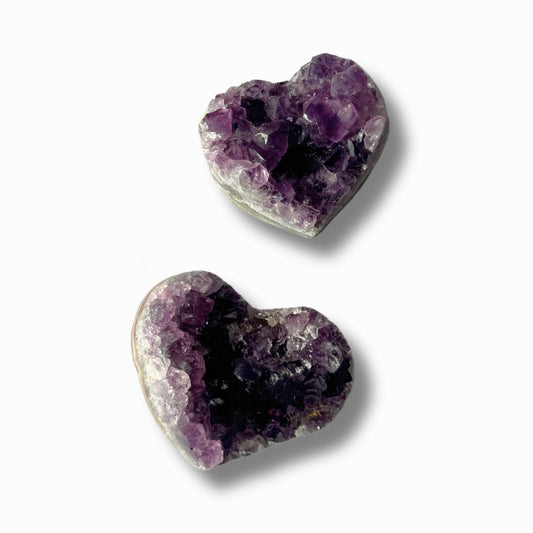 Herzförmige Amethyst-Druse mit funkelnden Kristallspitzen, auf hellem Hintergrund.