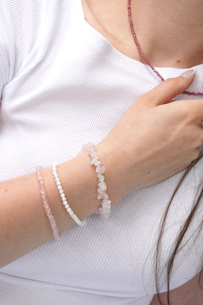 Nahaufnahme von Rosenquarz-Splitterarmband und Kugelarbmand sowie ein Perlmuttarmband, kombiniert mit einer Halskette aus facettiertem pinkem Turmalin – femininer Edelsteinschmuck für Liebe und Herzenergie.