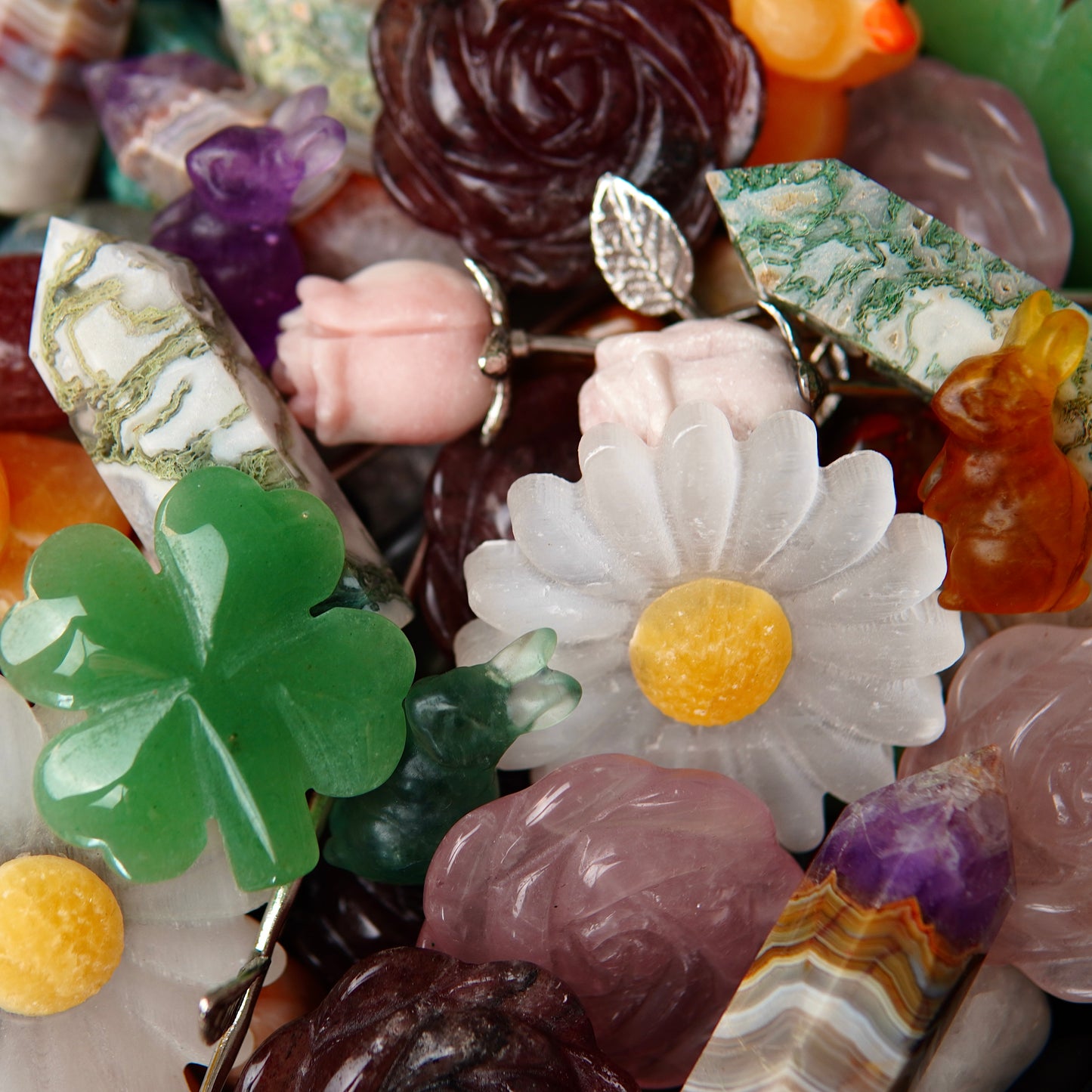 Detailaufnahme eines Edelsteinscoops von April mit glänzenden, polierten Kristallen in intensiven Farben und unterschiedlichen Formen, die im Licht schimmern.