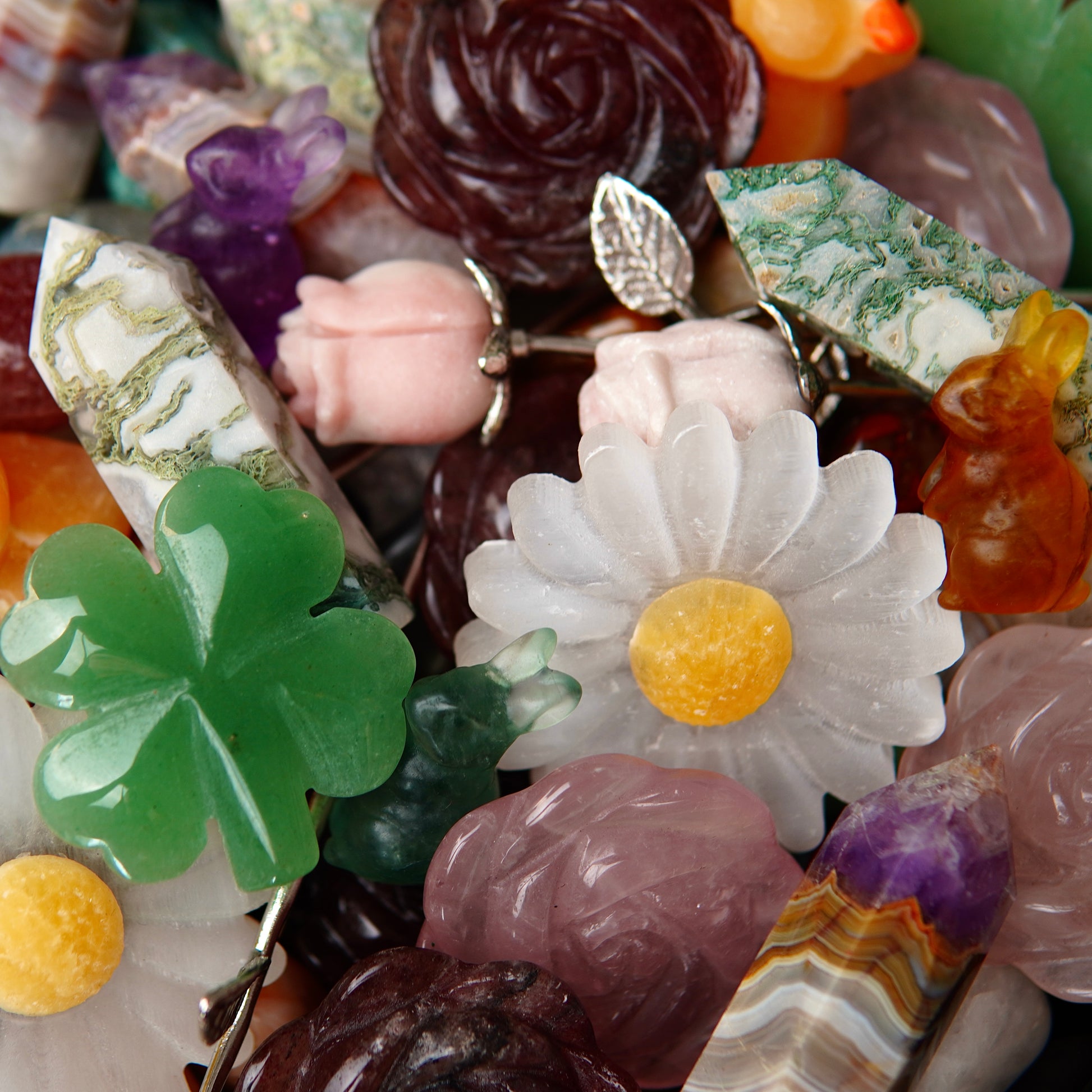 Detailaufnahme eines Edelsteinscoops von April mit glänzenden, polierten Kristallen in intensiven Farben und unterschiedlichen Formen, die im Licht schimmern.