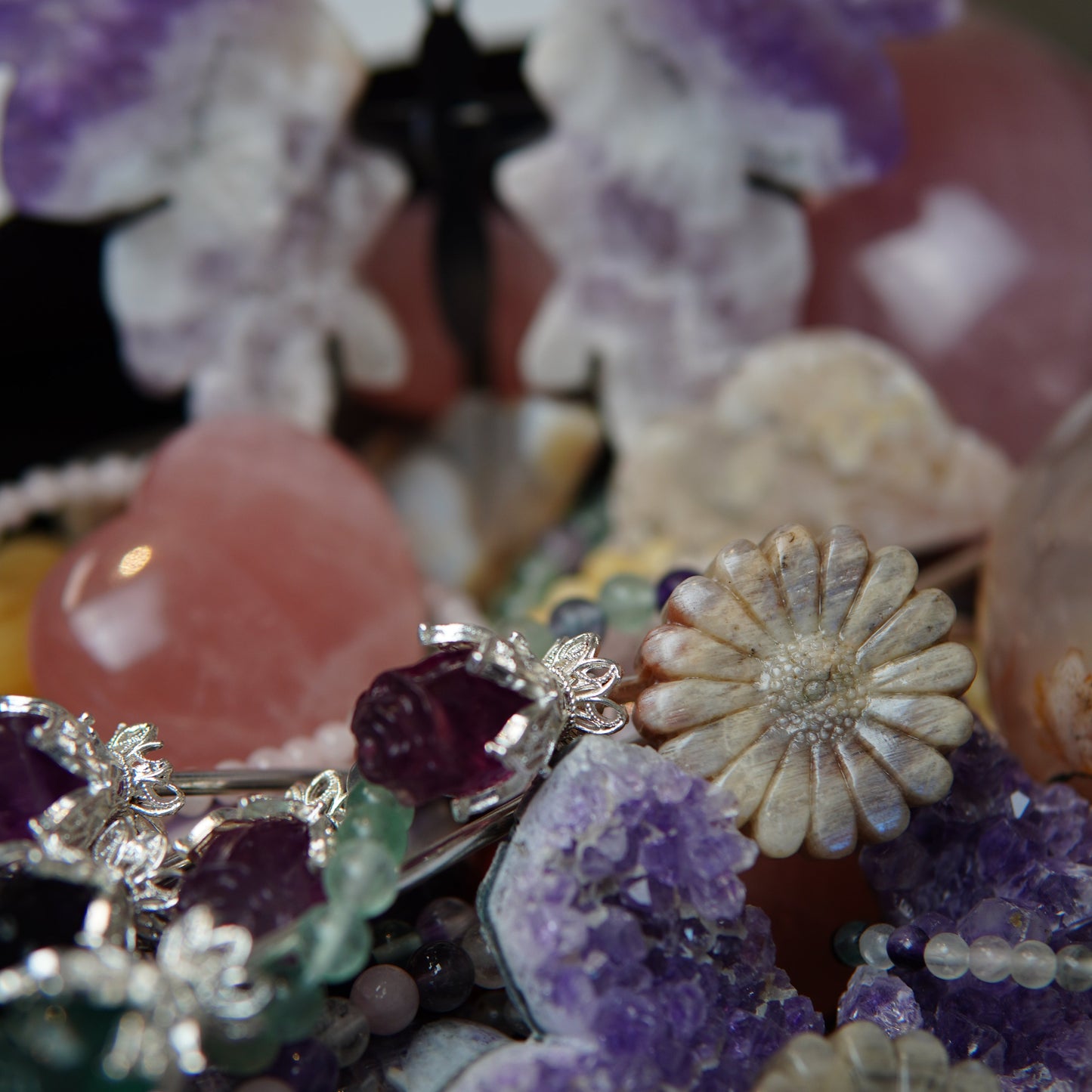 Detailaufnahme eines Edelsteinscoops von Februar mit glänzenden, polierten Kristallen in intensiven Farben und unterschiedlichen Formen, die im Licht schimmern.