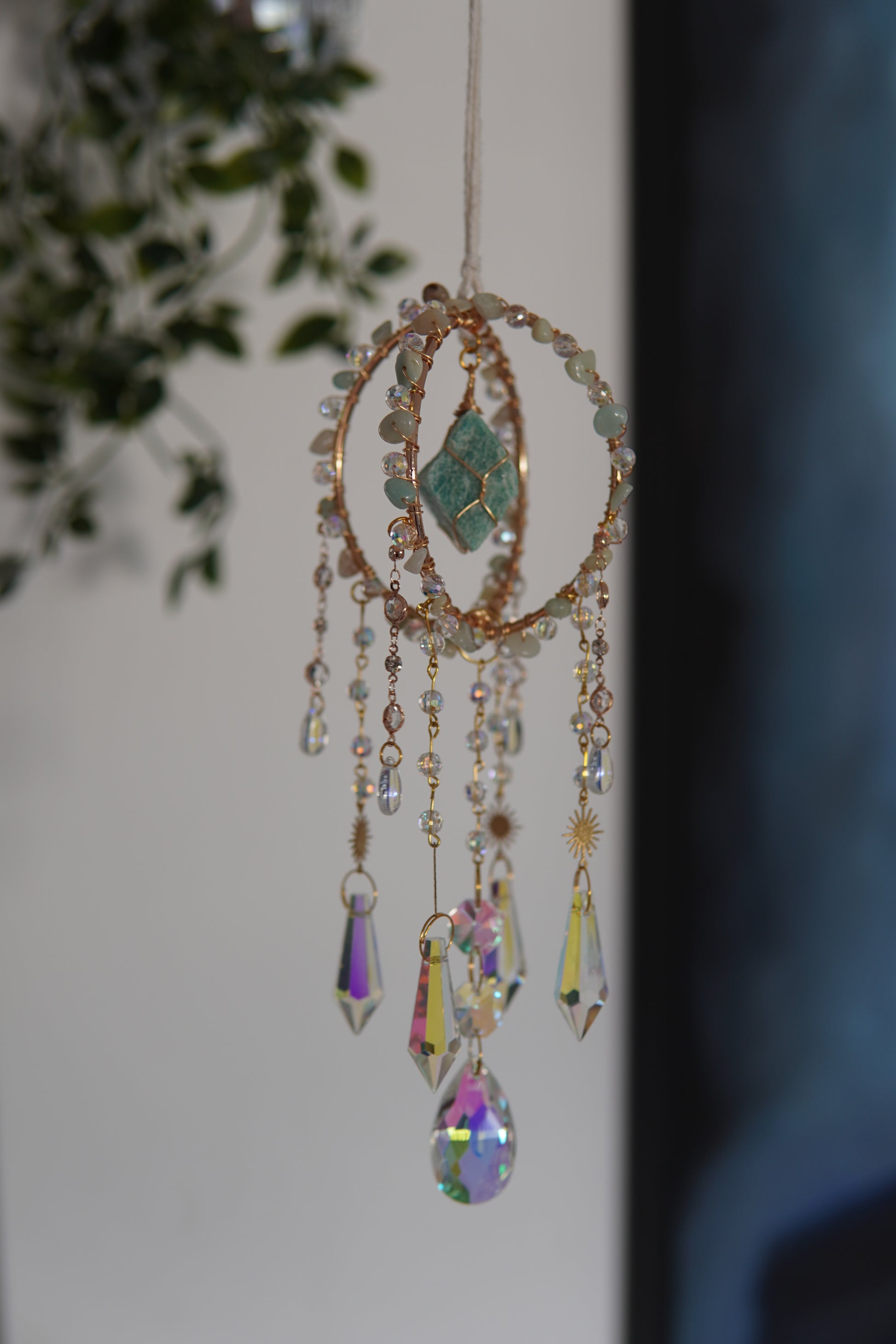 Fensterdeko aus Amazonit und Regenbogen funkelnden Kristallen – Sonnenfänger mit Edelsteinen für spirituelle Räume und als besondere Geschenkidee.
