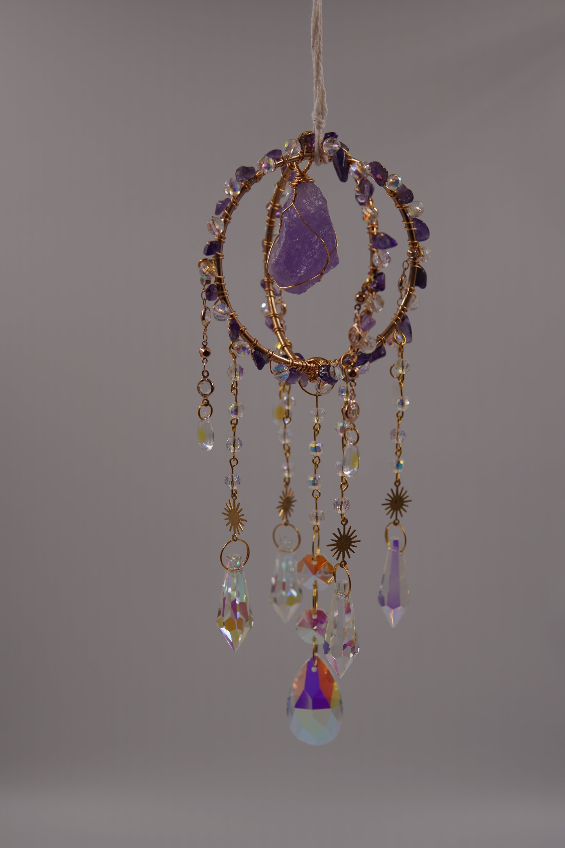 onnenfänger mit Amethyst, goldenen Details und Kristallanhängern – spirituelle Fensterdeko mit Edelsteinen, ideal für Lichtenergie und als handgemachte Geschenkidee.