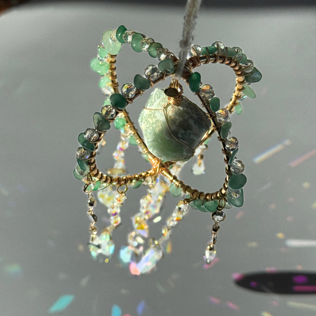 Sonnenfänger mit Aventurin, eingefasst in grüner Drahtoptik und Kristall-Elementen – lebendige Lichtfänger-Deko mit Edelsteinen für spirituelle Räume oder als Geschenk.