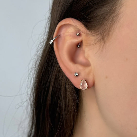Getragener Ohrstecker am Ohr in Tropfenform mit Rosenquarz - feminin und sanft.