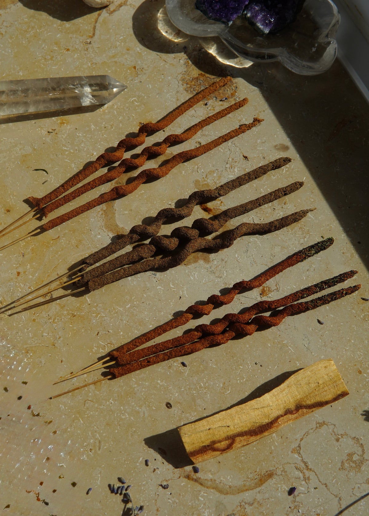 Räucherstäbchen-Set mit 9 Stäbchen und einem Palo-Santo-Holz, ordentlich nebeneinander angeordnet.