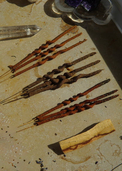 Räucherstäbchen-Set mit 9 Stäbchen und einem Palo-Santo-Holz, ordentlich nebeneinander angeordnet.