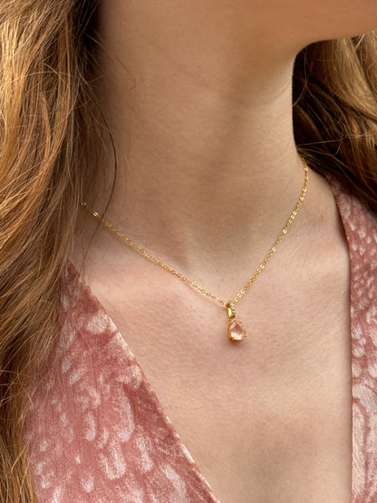 Zarte Halskette mit Rosenquarz und Zirkonia- Tropfenanhänger an goldfarbener Kette. Getragen an einem weiblichen Hals, ideal für Liebe, Harmonie und Selbstfürsorge.
